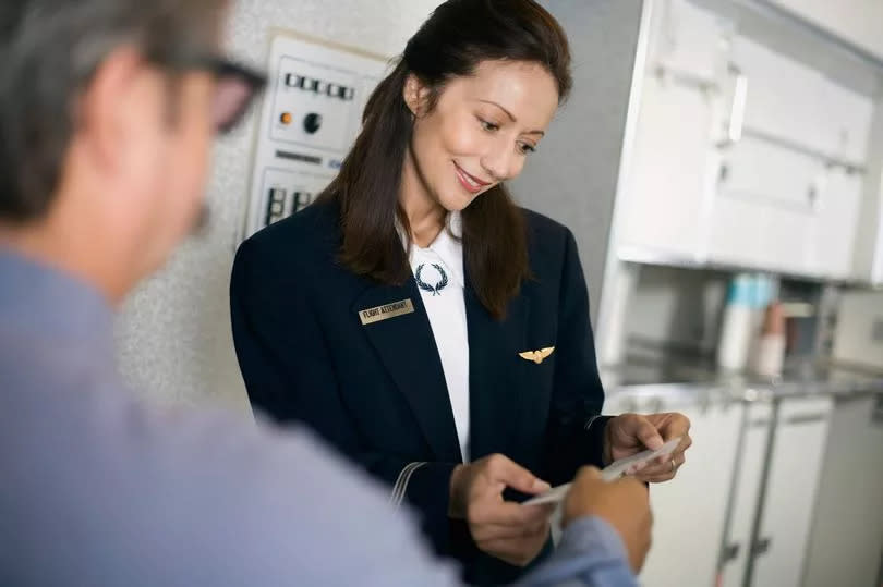 Flight attendant checking boarding pass