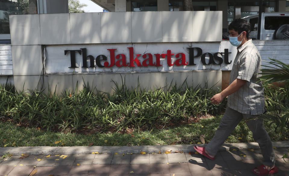 A man walks in front of the Jakarta Post newspaper building in Jakarta, Indonesia, Friday, Aug. 28, 2020. Indonesia’s leading English-language newspaper, The Jakarta Post, is considering laying off its staff as it struggles with the pandemic, a spokesperson for the publication's owner said Friday. (AP Photo/Achmad Ibrahim)