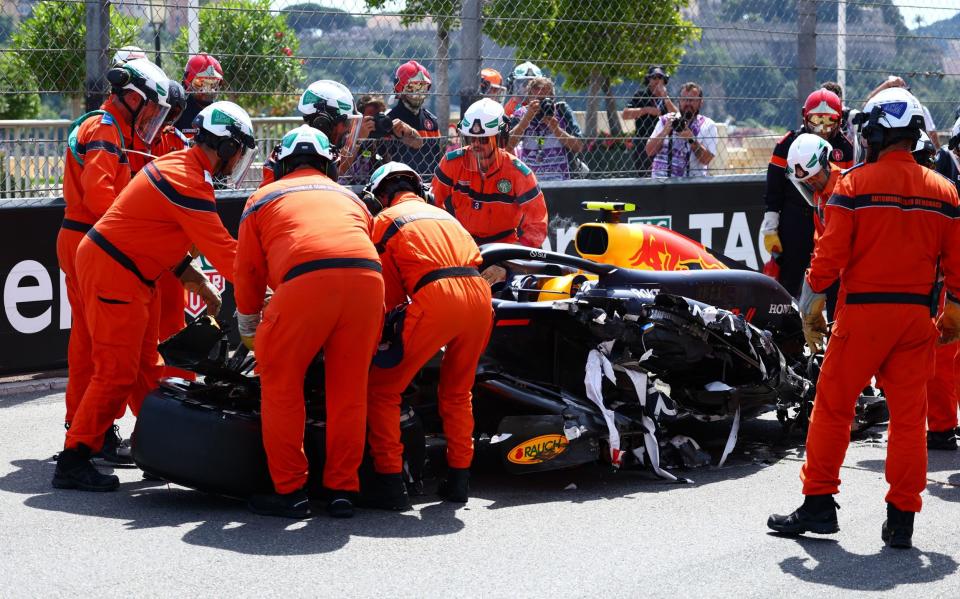 Sergio Perez's car is attended to by the stewards after his crash