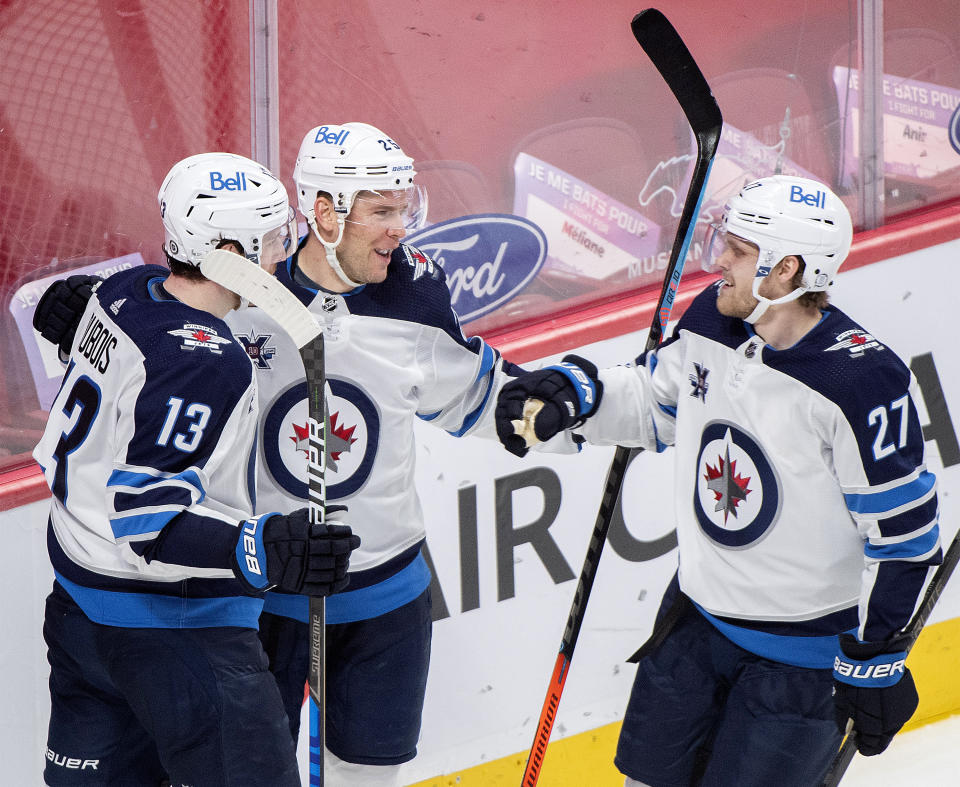 Winnipeg Jets' Paul Stastny (25) celebrates his goal with teammates Pierre-Luc Dubois (13) and Nikolaj Ehlers (27) during second-period NHL hockey game action against the Montreal Canadiens in Montreal, Saturday, April 10, 2021. (Graham Hughes/The Canadian Press via AP)