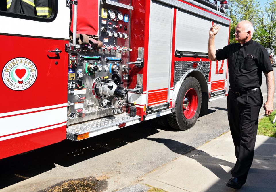 Fire Department chaplain Rev. Walter Riley blesses the newest edition to the fleet, Engine 12, at Worcester Fire Department headquarters May 17, 2017.