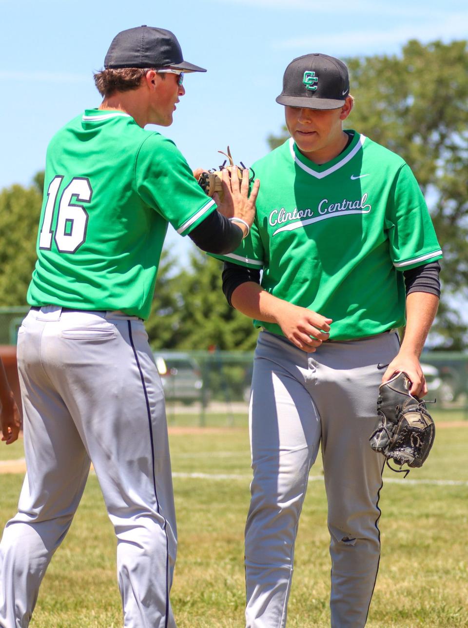 Luke Davison listens to Troy Smith (16) as he walks off the pitcher's mound.