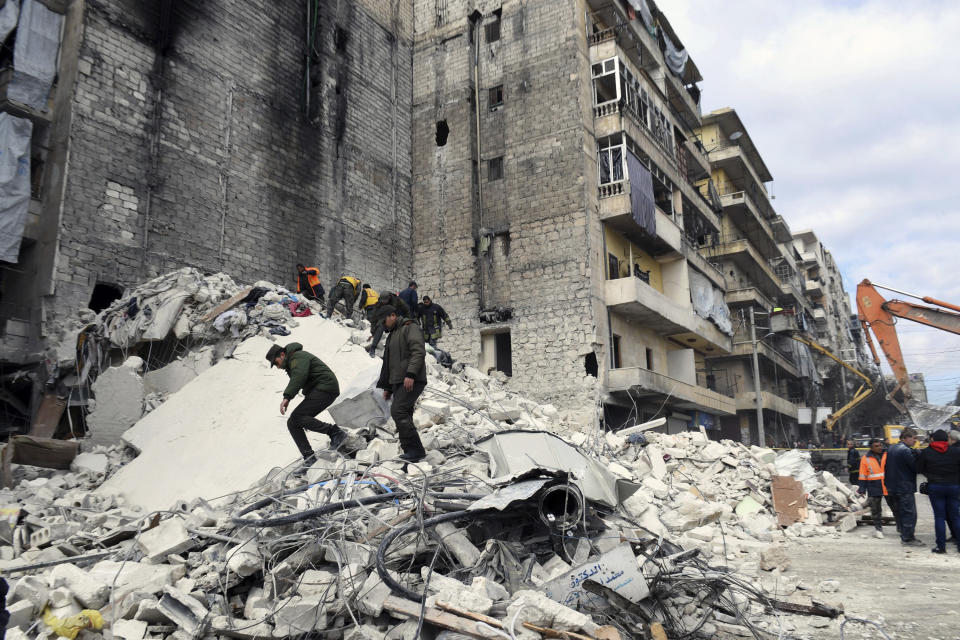 In this photo released by the Syrian official news agency SANA, people inspect a destroyed building where, according to SANA, the five-story building collapsed early Saturday, Feb. 2, 2019, killing most of those who were inside and only one person was rescued alive, in the northern city of Aleppo, Syria. SANA said that a building damaged during years of war in the northern city of Aleppo has collapsed killing 11 people. (SANA via AP)