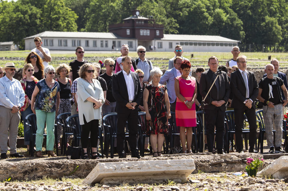 People hold a minute of silence for prisoners assigned a pink triangle in the former Nazi concentration camp Buchenwald within the Christopher Street Day in Weimar, Germany, Sunday, June 23, 2019. There were 650 prisoners assigned a pink triangle in the Buchenwald concentration camp between 1937 and 1945. Many of them lost their lives. (AP Photo/Jens Meyer)