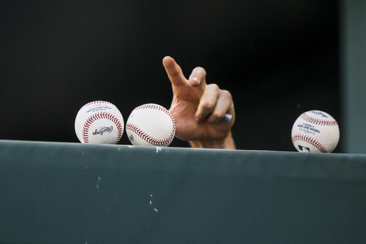 A New York Yankees player reaches for a baseball to sign for some kids in the stands on October 5, 2022 at Globe Life Field in Arlington, Texas. (Photo by Matthew Pearce/Icon Sportswire via Getty)