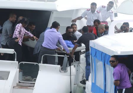 Officials carry an injured woman off the speed boat of Maldives President Abdulla Yameen (not pictured) after an explosion onboard, in Male, Maldives September 28, 2015. REUTERS/Waheed Mohamed