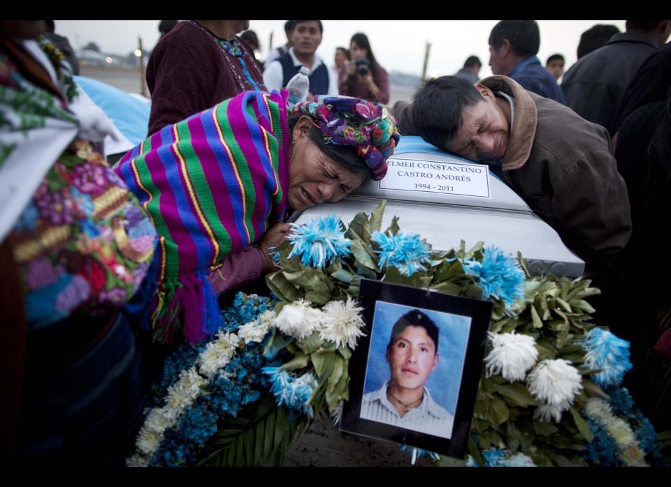 Natalia Andres Lopez, left, and another relative, mourn over the coffin containing the body of her cousin, at an Air Force base in Guatemala City , Wednesday, March 21, 2012. (AP Photo/Rodrigo Abd)