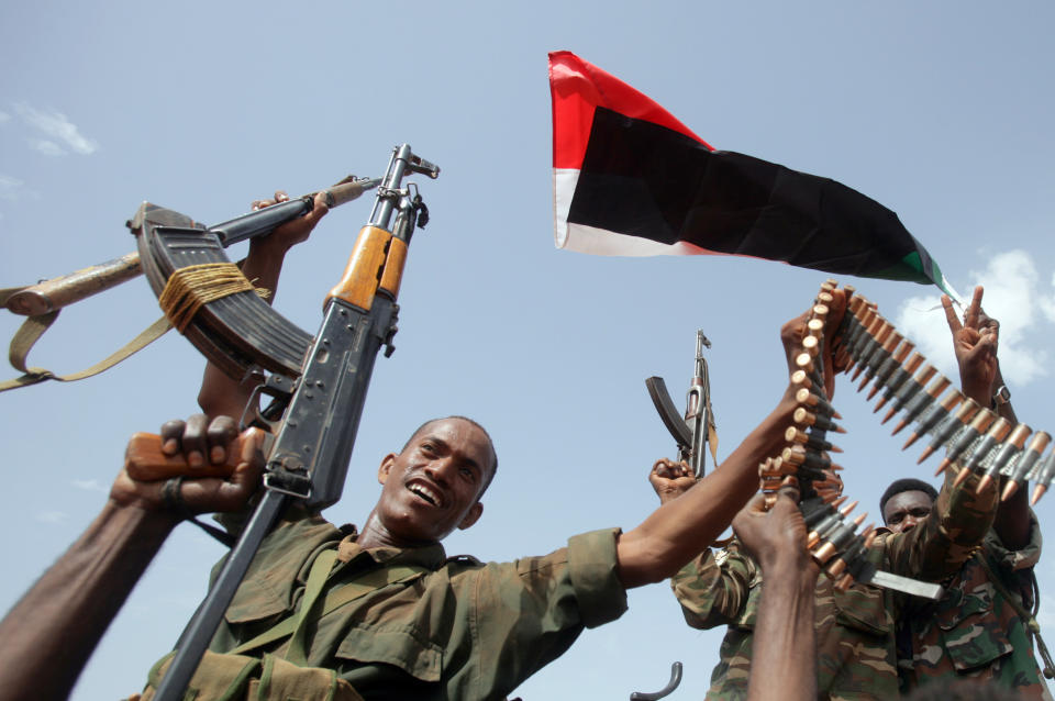 Sudanese armed forces raise their weapons during a visit by President Omar al-Bashir in Heglig, Sudan, Monday, April 23, 2012. Sudanese warplanes bombed a market and an oil field in South Sudan, killing at least two people hours after Sudanese ground forces reportedly crossed into South Sudan with tanks and artillery, elevating the risk of all-out war between the two old enemies. Al-Bashir vowed Monday to press ahead with his military campaign until all southern troops or affiliated forces are chased out of the north.(AP Photo)