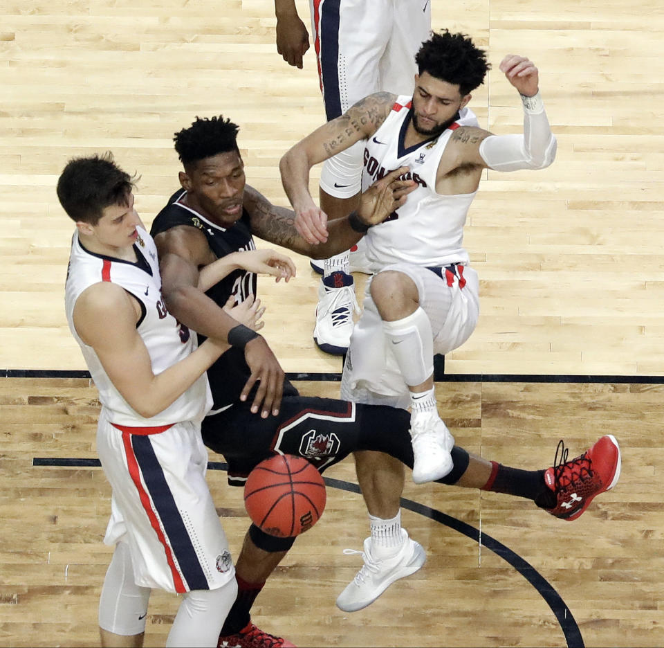 South Carolina's Chris Silva (30) passes the ball between Gonzaga's Zach Collins, left, and Josh Perkins during the second half in the semifinals of the Final Four NCAA college basketball tournament, Saturday, April 1, 2017, in Glendale, Ariz. (AP Photo/David J. Phillip)