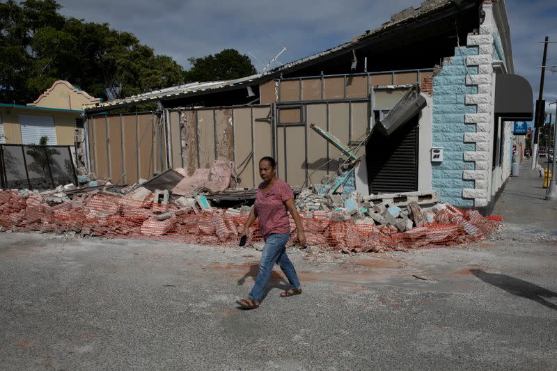 FILE PHOTO: A woman walks past a damaged store after an earthquake in Guanica