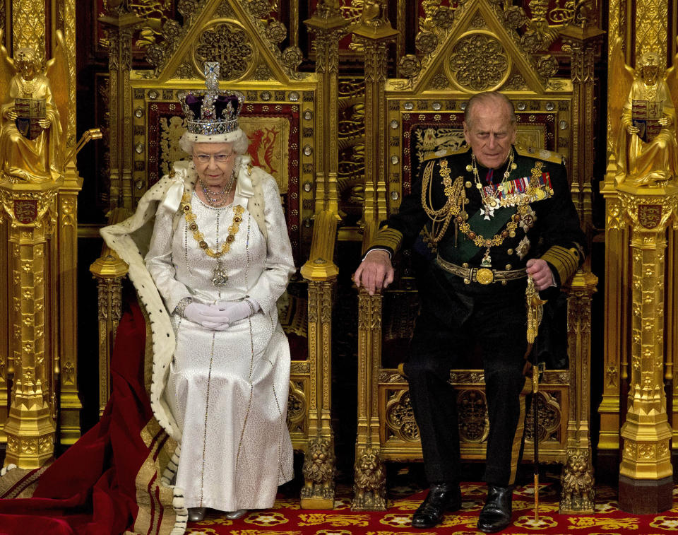 FILE - In this Wednesday, May 9, 2012 file photo, Britain's Queen Elizabeth II sits next to Prince Philip in the House of Lords as she waits to read the Queen's Speech to lawmakers in London. Buckingham Palace says Prince Philip, husband of Queen Elizabeth II, has died aged 99. (AP Photo/Alastair Grant, File)