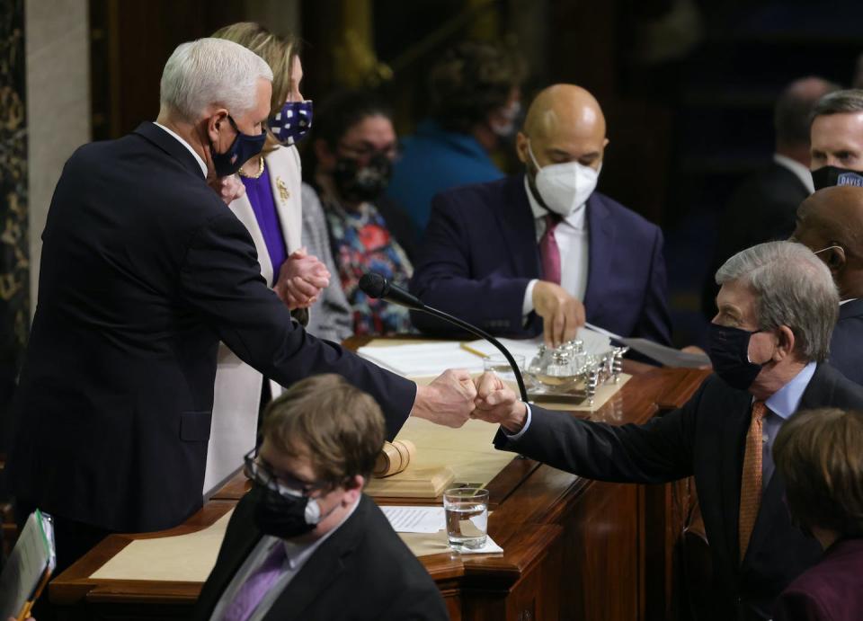 Vice President Mike Pence, left, bumps fists with U.S. Sen. Roy Blunt, R-Mo., at the conclusion of the count of electoral votes in the House chamber during a reconvening of a joint session of Congress on Jan. 7, 2021. <a href="https://www.gettyimages.com/detail/news-photo/vice-president-mike-pence-bumps-fists-with-u-s-sen-roy-news-photo/1295001444?phrase=Electoral%20college%20vote&adppopup=true" rel="nofollow noopener" target="_blank" data-ylk="slk:Photo by Win McNamee/Getty Images;elm:context_link;itc:0;sec:content-canvas" class="link ">Photo by Win McNamee/Getty Images</a>