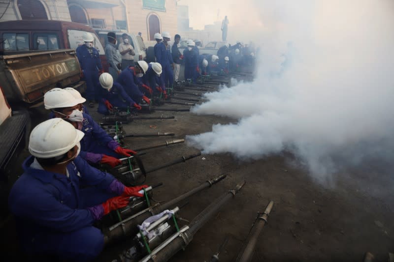 Health workers spray insecticides as they begin fumigating residential areas to curb the spread of dengue fever in Hodeidah