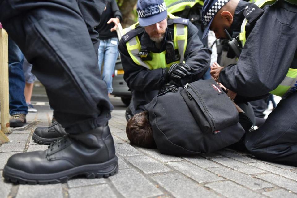 A woman is detained by police (Rex Features)