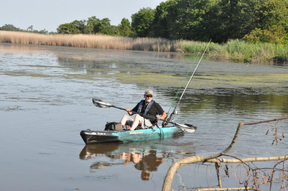 Joe Harvilla paddles his kayak on his way to fish July 11 at the pond at Delaware City dikes along Cox Neck Road west of Delaware City.