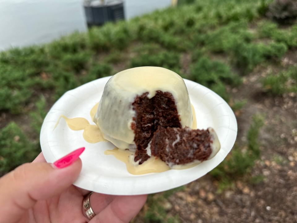 hand holding plate of warm chocolate pudding from epcot food and wine