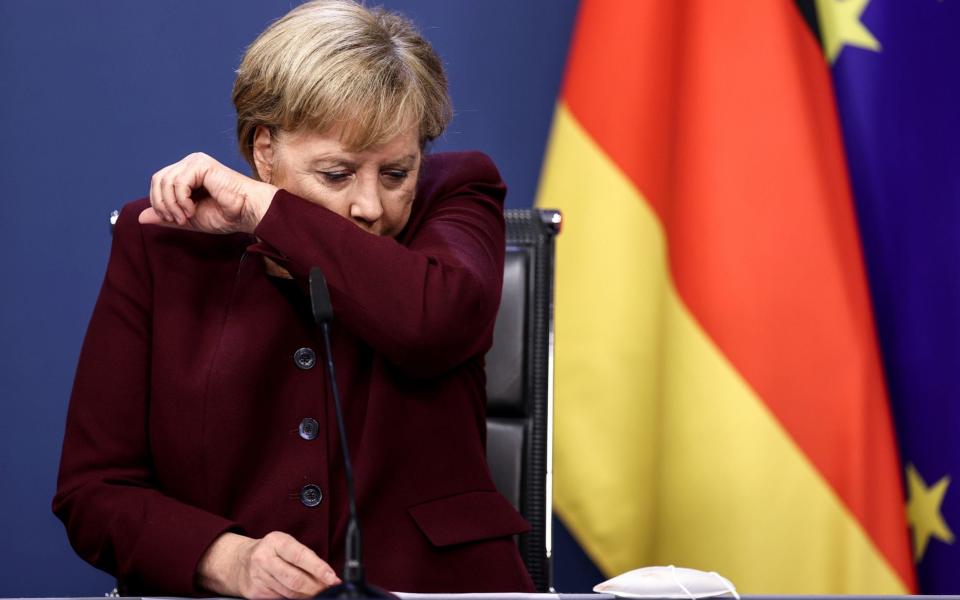 Angela Merkel coughing during a press conference after an EU summit in Brussels  - Reuters