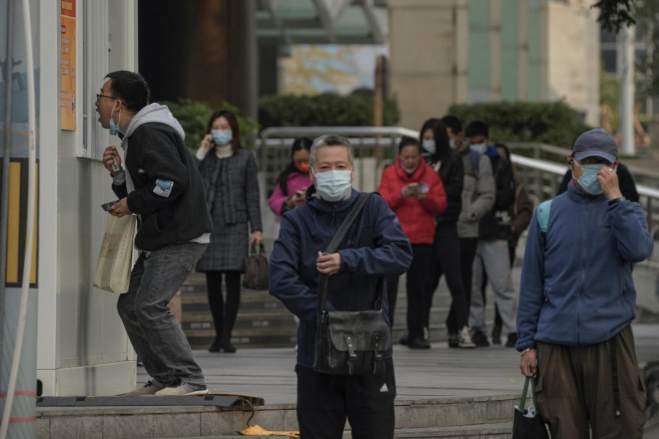 Residents line up to get their routine COVID-19 throat swabs at a coronavirus testing site setup along a pedestrian walkway in Beijing, Wednesday, Nov. 2, 2022. (AP Photo/Andy Wong)