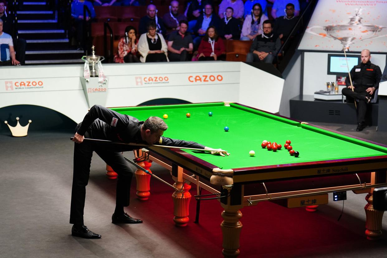Mark Selby takes on a pot as Luca Brecel watches on (PA)