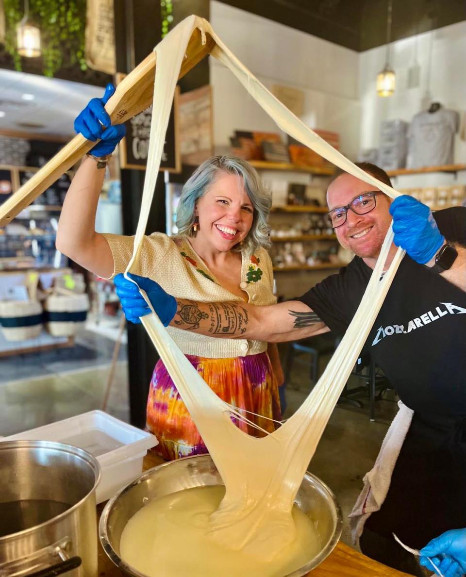 Tabitha Cronholm gets help from chef Ron Tulotta to achieve maximum stretch for her mozzarella cheese at a cheese-making class sponsored by Butcher and Bear at Sunago Coffee Co., June 2, 2023.