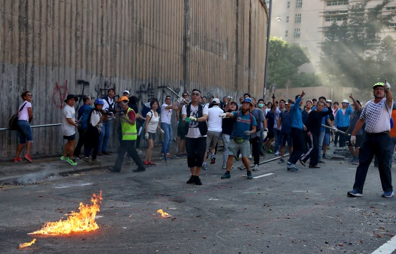 Local residents react after an anti-government protester threw a molotov cocktail outside the University of Hong Kong