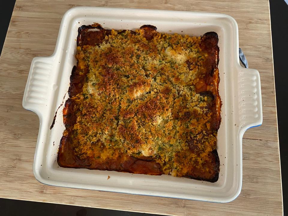 Eggplant Parmesan layered with breadcrumbs in a baking dish after coming out of the oven.