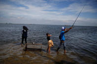 Youth play as sea water rises during high tide at Kali Adem port in Jakarta, Indonesia, January 4, 2018. REUTERS/Beawiharta