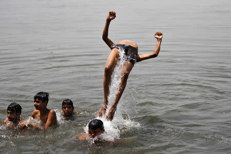 A boy somersaults in the waters of the Yamuna river on a hot summer day in New Delhi, India, April 22, 2016. REUTERS/Anindito Mukherjee