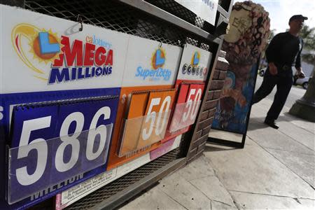 A man walks past a Mega Millions lottery sign with the estimated jackpot of $586 million posted in Los Angeles, California December 16, 2013. REUTERS/Jonathan Alcorn