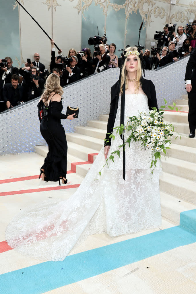 Elle Fanning attends The 2023 Met Gala in a white lace gown