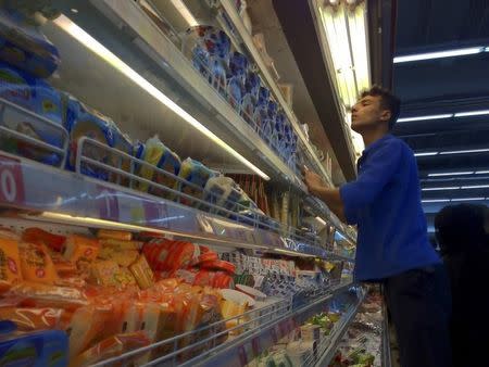 An Iranian employee checks the food shelves at a shopping mall in northwestern Tehran February 3, 2012. REUTERS/Morteza Nikoubazl