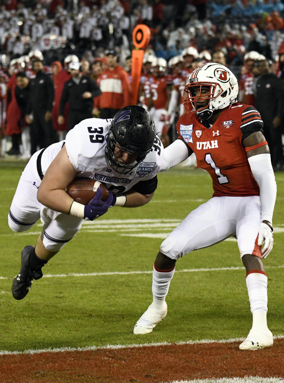 Northwestern offensive lineman Trey Klock (39) dives past Utah defensive back Jaylon Johnson (1) for a touchdown during the second half of the Holiday Bowl NCAA college football game against Utah, Monday, Dec. 31, 2018, in San Diego. (AP Photo/Denis Poroy)