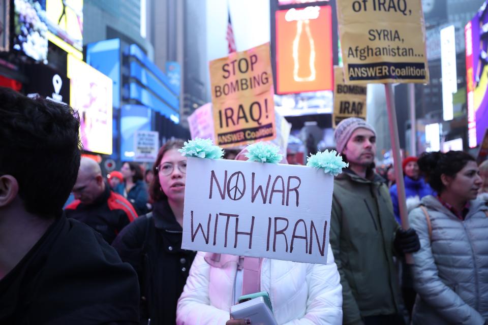 NEW YORK, USA - JANUARY 04 : Anti-war activists hold banners during a protest organised by 'Answer Coalition' at Times Square following the killing of Iranian Revolutionary Guards' Quds Force commander Qasem Soleimani by a US airstrike in the Iraqi capital Baghdad, on January 4, 2020 in New York, United States. (Photo by Tayfun Coskun/Anadolu Agency via Getty Images)