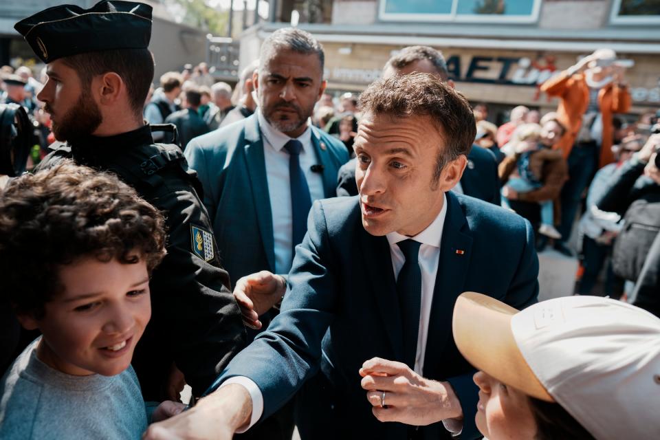 Emmanuel Macron greets well-wishes near a polling station in Le Touquet, northern France, on Sunday (AP)