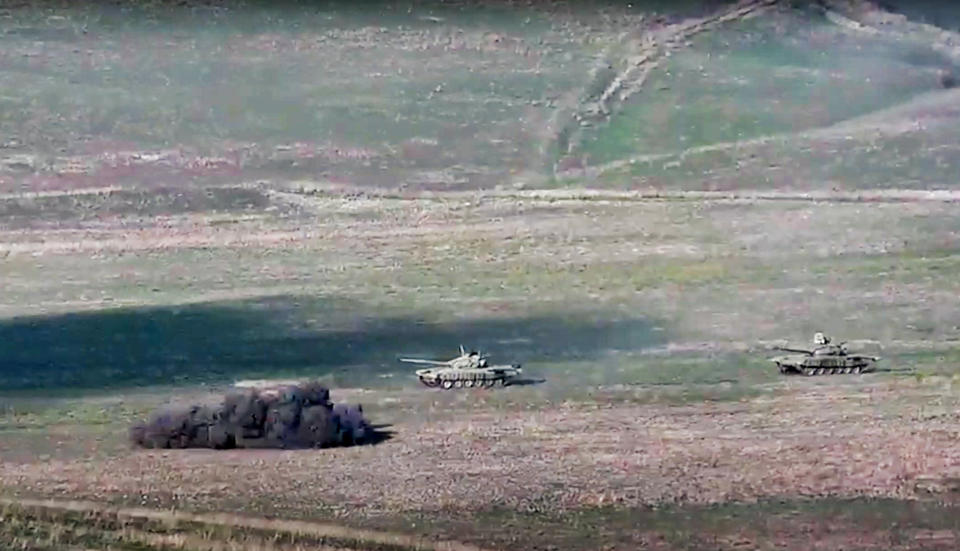 In this image taken from a footage released by Armenian Defense Ministry on Sunday, Sept. 27, 2020, Armenian army destroys Azerbaijani tanks at the contact line of the self-proclaimed Republic of Nagorno-Karabakh, Azerbaijan. Fighting between Armenia and Azerbaijan has broken out around the separatist region of Nagorno-Karabakh and the Armenian Defense Ministry says two Azerbaijani helicopters have been shot down. Ministry spokeswoman Shushan Stepanyan also said Armenian forces hit three Azerbaijani tanks. (Armenian Defense Ministry via AP)