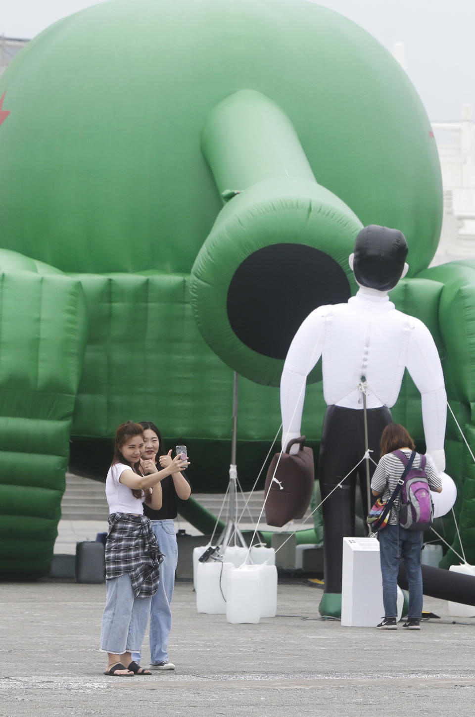 Tourists take a selfie with an inflatable tank man at the Liberty Square of Chiang Kai-shek Memorial Hall in Taipei, Taiwan, Saturday, June 1, 2019. An artist erected the inflatable display in Taiwan’s capital to mark an iconic moment in the Tiananmen Square pro-democracy protests. The larger-than-life balloon installation, which stands in front of Taipei’s famous hall, portrays a peaceful encounter between a Chinese civilian and the military tanks that contributed to a brutal shutdown of the demonstrations in Beijing on June 4, 1989. (AP Photo/Chiang Ying-ying)