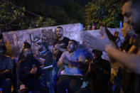 Palestinians sing during an ongoing protest against the forcible eviction of Palestinians from their homes in the Sheikh Jarrah neighborhood of east Jerusalem, Friday, May 7, 2021. Dozens of Palestinian families in east Jerusalem are at risk of losing their homes to Jewish settler groups following a decades-long legal battle. The threatened evictions have sparked weeks of protests and clashes in recent days, adding to the tensions in Jerusalem. (AP Photo/Maya Alleruzzo)