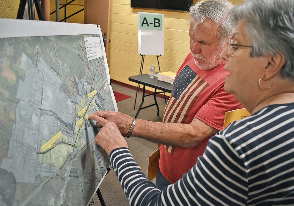 Swansea residents Roger and Maureen Bombardaer look at the proposed sewer map before the Swansea special and annual town meeting Monday, May 20 at Joseph Case High School.