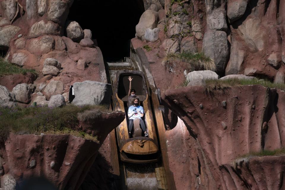 Guests in a log-shaped car travel down a slope in the Splash Mountain attraction at Disneyland.