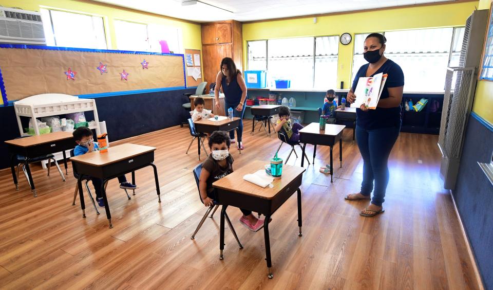 Instructor Chablis Torres reads to preschoolers, wearing masks and spaced appropriately apart as per coronavirus guidelines, during a summer school session.