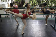 In this photo taken Nov. 25 2012, Filipino slum dweller Jessa Balote, center, balances during a class at Ballet Manila at the Philippine capital. Balote, who used to tag along with her family as they collect garbage at a nearby dumpsite, is a scholar at Ballet Manila's dance program. As an apprentice, she makes around 7,000 pesos ($170) a month, sometimes double that, from stipend and performance fees. (AP Photo/Aaron Favila)