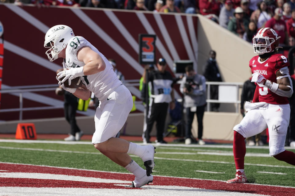 Michigan State's Tyler Hunt (97) makes a touchdown reception against Indiana's Marcelino McCrary-Ball (9) during the second half of an NCAA college football game, Saturday, Oct. 16, 2021, in Bloomington, Ind. Michigan State won 20-15. (AP Photo/Darron Cummings)