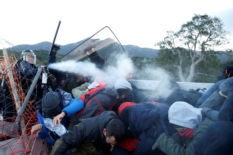 Members of Catalan protest group Democratic Tsunami clash with French police officers at the AP-7 highway