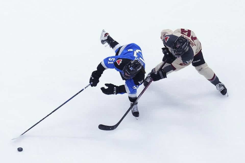 Toronto's Victoria Bach vies for the puck against Montreal's Sarah Bujold during the first period of a PWHL hockey game Friday, Feb. 16, 2024, in Toronto. (Chris Young/The Canadian Press via AP)