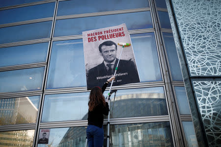 Environmental activists block the entrance of the Ministry of Ecology, Energy and Sustainable Development during a "civil disobedience action" to urge world leaders to act against climate change, in La Defense near Paris, France, April 19, 2019. The slogan reads " Macron, President of polluters". REUTERS/Benoit Tessier