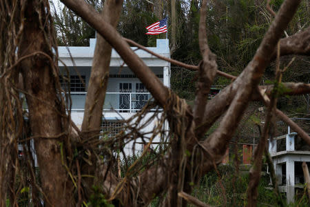 The U.S. flag flies near a home damaged by Hurricane Maria in the Trujillo Alto municipality outside San Juan, Puerto Rico, October 9, 2017. REUTERS/Shannon Stapleton