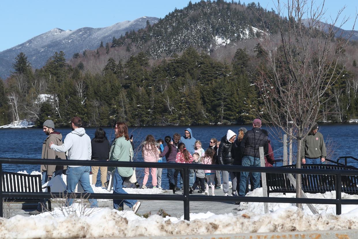 People enjoy a sunny day along Mirror Lake in Lake Placid April 7, 2024. Many are in town for the solar eclipse on Monday.