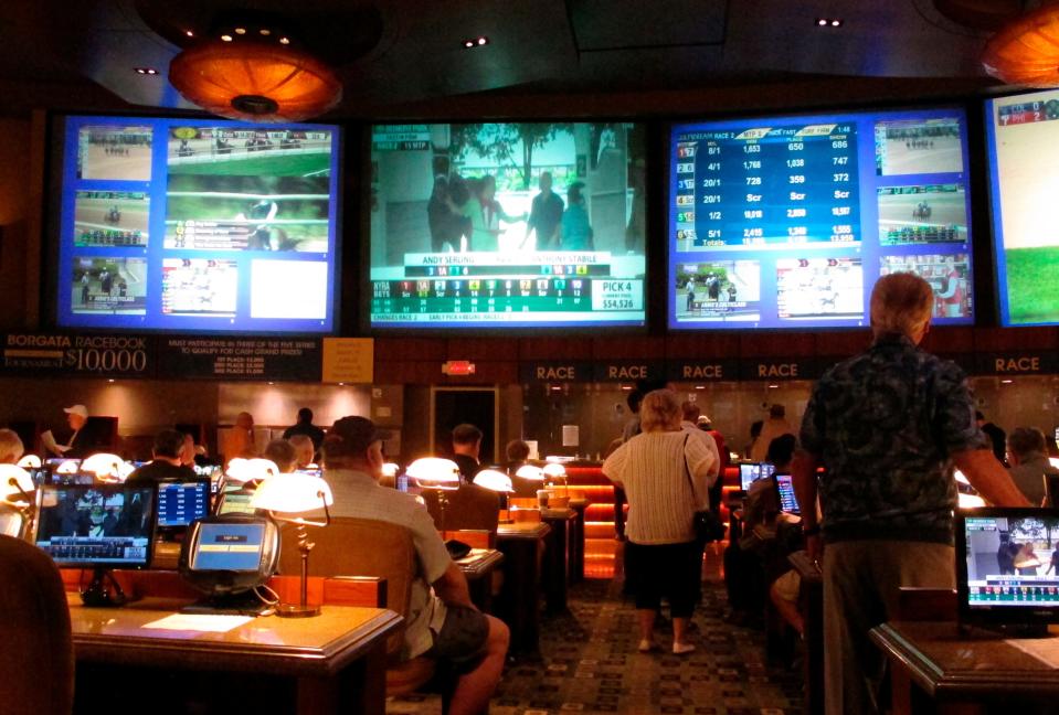 In this June 14, 2018 photo, bettors wait to make wagers on sporting events at the Borgata casino in Atlantic City, N.J., hours after it began accepting sports bets. The Borgata announced, Wednesday, Jan. 9, 2019, it will begin an $11 million expansion of its sports betting facility, to be completed by summer. (AP Photo/Wayne Parry)