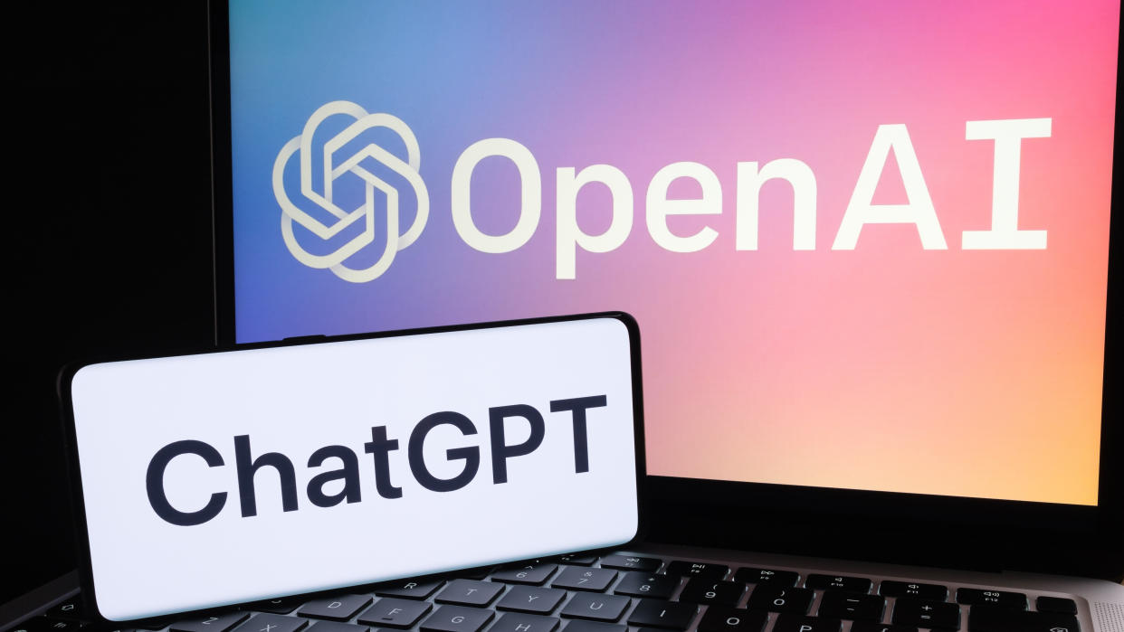  A phone with the ChatGPT logo and a laptop with the OpenAI logo. 