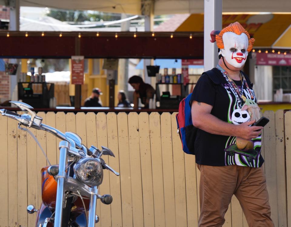 Anthony Daniels, a toy maker from Orlando, strolls Main Street during Biketoberfest in one of the many masks that he brings along to the event. "I come here every year," he said.